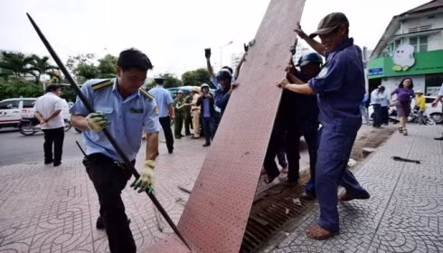 Quận 1 tiến hành tháo dỡ một tấm thép lấn chiếm vỉa hè của người đi bộ (ảnh: TTO)