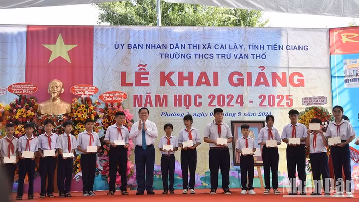 Trưởng Ban Tuyên giáo Trung ương Nguyễn Trọng Nghĩa tặng học bổng cho các em học sinh nghèo nhân dịp lễ khai giảng.