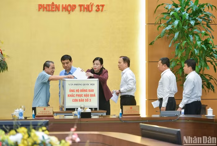 Các Ủy viên Ủy ban Thường vụ Quốc hội ủng hộ đồng bào khắc phục hậu quả cơn bão số 3. (Ảnh: Duy Linh)