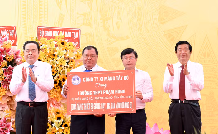 Chủ tịch Quốc hội Trần Thanh Mẫn chứng kiến lãnh đạo Công ty Xi măng Tây Đô trao kinh phí 400 triệu đồng hỗ trợ nhà trường mua thiết bị dạy học. Ảnh: Lâm Hiển