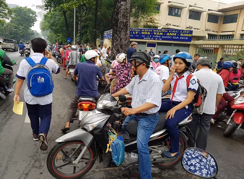 Chở con ra về, chuẩn bị tiếp tục cho bài làm thi vào buổi chiều (Ảnh: P.L)