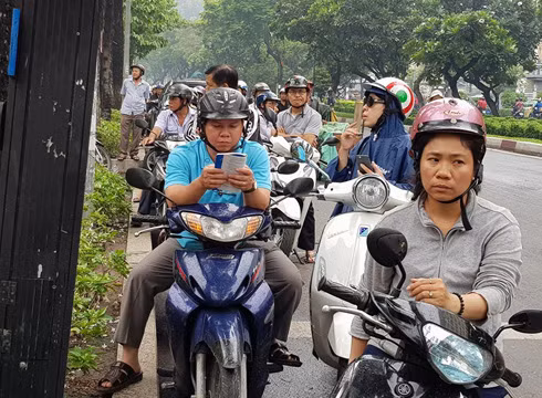 Chờ đợi con, một phụ huynh "giết thời gian" bằng cách đọc sách cho vơi nỗi lo lắng (ảnh: P.L)