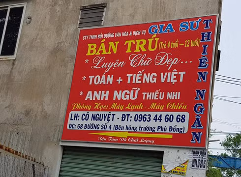 Một bảng quảng cáo của Thiên Ngân được treo trên bờ tường bên hông một trường tiểu học (ảnh: P.L)