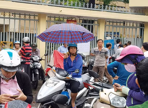 Dù cho trời mưa, ba mẹ vẫn quyết tâm đứng đợi con thi xong rồi mới chịu ra về (ảnh: P.L)