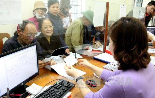 Cán bộ Bảo hiểm Xã hội Việt Nam giải đáp cho khách hàng. Ảnh: TTXVN Cán bộ Bảo hiểm Xã hội Việt Nam giải đáp cho khách hàng. Ảnh: TTXVN