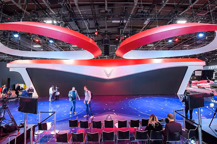 Logo hình chữ V nằm chính giữa sân khấu, hai cánh trải ra hai bên mô phỏng đèn xe “mắt hi” của VinFast. Viền đỏ chạy dài tại phần sải cánh của màn hình đem lại cảm giác mới mẻ, tràn đầy năng lượng.