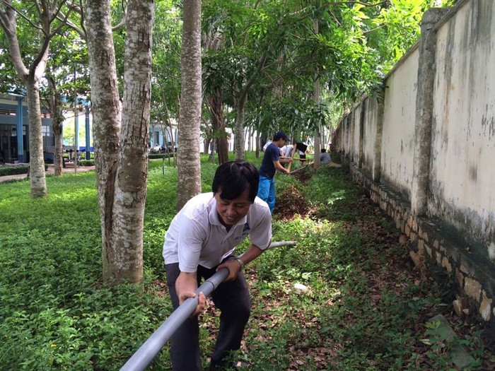 Thầy Lê Phước Triều đang cùng học sinh lắp đặt hệ thống tưới nước vườn hoa. Ảnh tác giả cung cấp