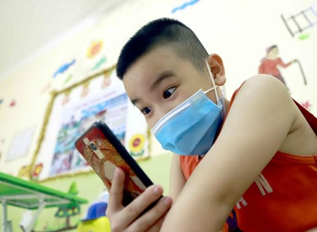 Một học sinh thích thú khi được gọi điện thoại có hình từ khu cách ly với bà nội. (Ảnh: Hoàng Hùng/TTXVN) Một học sinh thích thú khi được gọi điện thoại có hình từ khu cách ly với bà nội. (Ảnh: Hoàng Hùng/TTXVN)