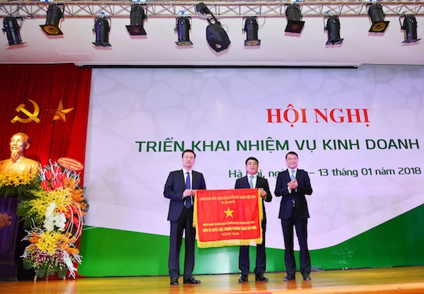 Ông Lê Minh Hưng - Ủy viên Ban chấp hành Trung ương Đảng, Bí thư Ban Cán sự Đảng, Thống đốc Ngân hàng Nhà nước Việt Nam (bên phải) thừa ủy quyền của Thủ tướng Chính phủ trao Cờ thi đua cho Vietcombank – Đơn vị xuất sắc trong phong trào thi đua Ông Lê Minh Hưng - Ủy viên Ban chấp hành Trung ương Đảng, Bí thư Ban Cán sự Đảng, Thống đốc Ngân hàng Nhà nước Việt Nam (bên phải) thừa ủy quyền của Thủ tướng Chính phủ trao Cờ thi đua cho Vietcombank – Đơn vị xuất sắc trong phong trào thi đua