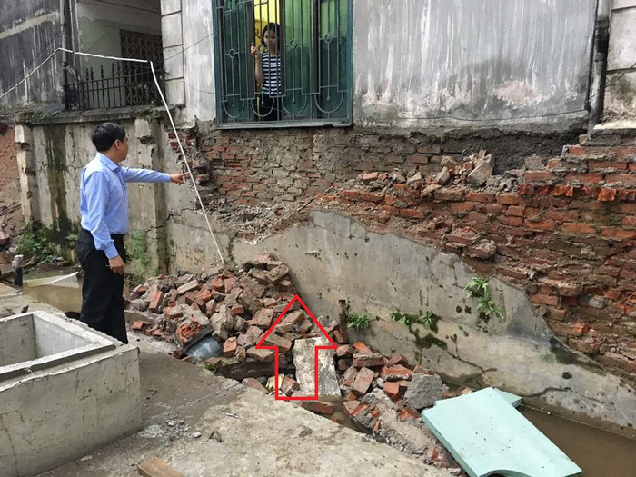 Bồn chứa dầu ngầm của dự án FLC Twin Towers nằm sát ngay cạnh nhà dân (mũi tên đỏ). Trong ảnh người dân đang chỉ vào bức tường cũ bị đơn vị thi công dự án tự ý đập phá, xâm phạm đến móng nhà nhiều hộ dân liền kề. Ảnh: V.P. Bồn chứa dầu ngầm của dự án FLC Twin Towers nằm sát ngay cạnh nhà dân (mũi tên đỏ). Trong ảnh người dân đang chỉ vào bức tường cũ bị đơn vị thi công dự án tự ý đập phá, xâm phạm đến móng nhà nhiều hộ dân liền kề. Ảnh: V.P.