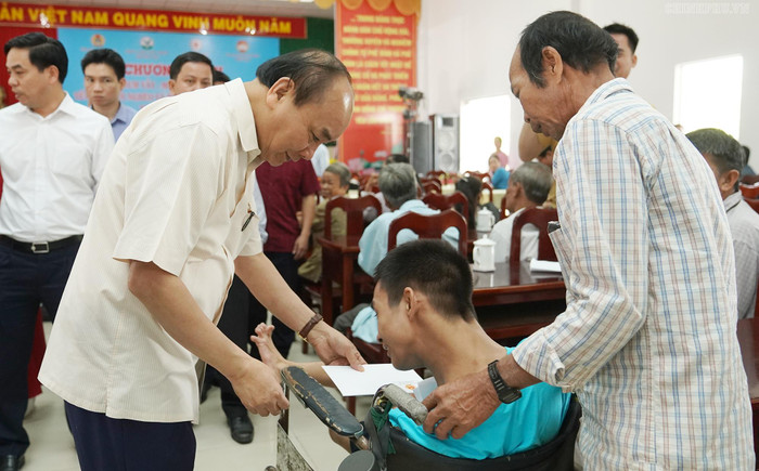 Thủ tướng Nguyễn Xuân Phúc tặng quà Tết cho nạn nhân chất độc da cam khi dự chương trình “Tết sum vầy” Xuân Canh Tý 2020 tại thị trấn Vũng Liêm, huyện Vũng Liêm, tỉnh Vĩnh Long. (Ảnh VGP/Quang Hiếu)