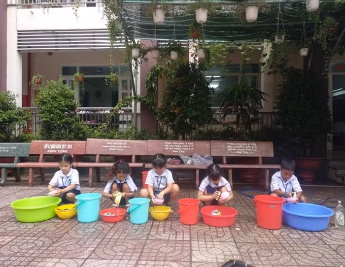Các em thực hành giúp cha mẹ rửa chén bát. (Ảnh: Nhà trường cung cấp)