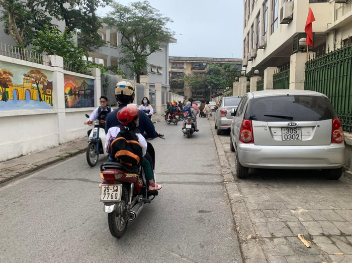 Theo ghi nhận của phóng viên Tạp chí Điện tử Giáo dục Việt Nam, 6h30 sáng, đoạn đường vào Trường Phổ thông Trung học Kim Liên (Đống Đa, Hà Nội) có rất nhiều học sinh đi xe gắn, xe máy điện, xe đạp điện nhưng không đội mũ bảo hiểm. Ảnh: Kim Anh.