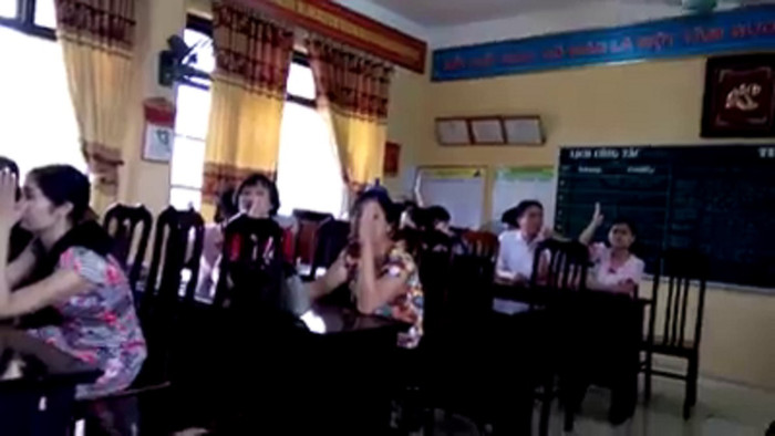 Hình ảnh cán bộ, giáo viên nhà trường dưới sự chỉ đạo của hiệu trưởng đã giơ tay hạ mức hoàn thành nhiệm vụ cô Nhung xuống mức không hoàn thành nhiệm vụ. Ảnh: Cắt từ video NVCC. Hình ảnh cán bộ, giáo viên nhà trường dưới sự chỉ đạo của hiệu trưởng đã giơ tay hạ mức hoàn thành nhiệm vụ cô Nhung xuống mức không hoàn thành nhiệm vụ. Ảnh: Cắt từ video NVCC.