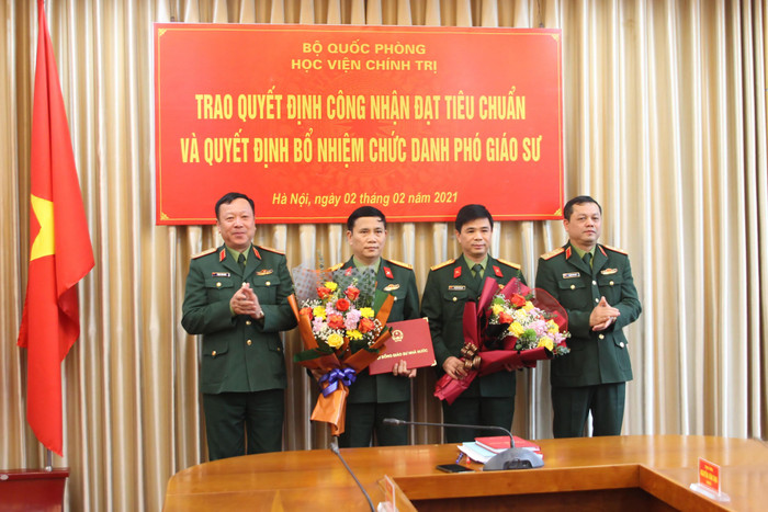 Trung tướng, Phó giáo sư, Tiến sĩ Nguyễn Văn Bạo, Giám đốc Học viện Chính trị và Thiếu tướng Phạm Tiến Dũng, Bí thư Đảng ủy, Chính ủy Học viện trao quyết định công nhận đạt tiêu chuẩn và Quyết định bổ nhiệm chức danh Phó Giáo sư cho các nhà giáo đạt tiêu chuẩn Phó Giáo sư năm 2020 của Học viện. (Ảnh do tác giả cung cấp)