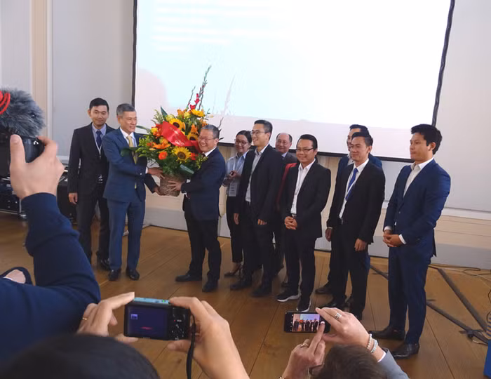 Giáo sư Nguyễn Xuân Thính nhận lẵng hoa của Bộ trưởng Nguyễn Chí Dũng do Đại sứ Nguyễn Minh Vũ trao tặng