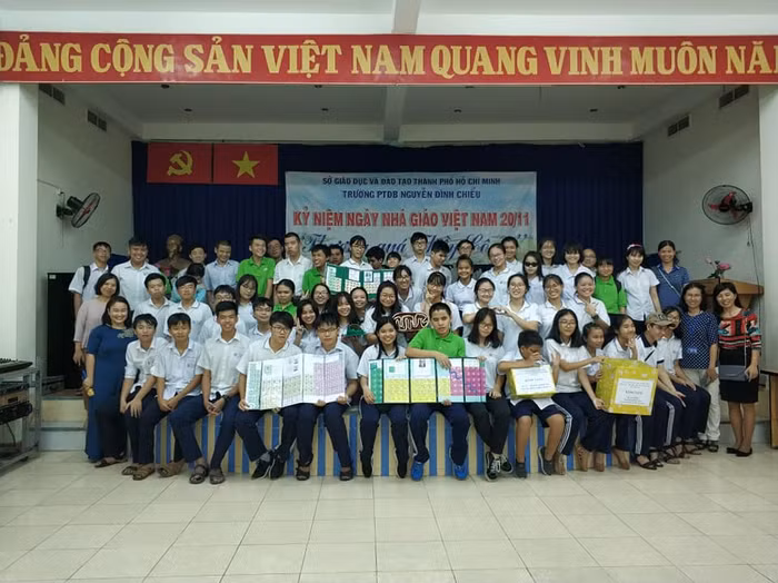 Cô Lê Thị Hồng Nhung (áo dài xanh hàng đầu, bìa trái) cùng học sinh trong buổi trao tặng sản phẩm dự án tại trường Phổ thông đặc biệt Nguyễn Đình Chiểu. Ảnh CTV