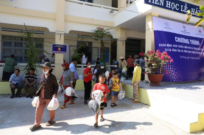 Trẻ em và người dân phấn khởi được khám bệnh, phát thuốc miễn phí và nhận quà. khambenh.jpg