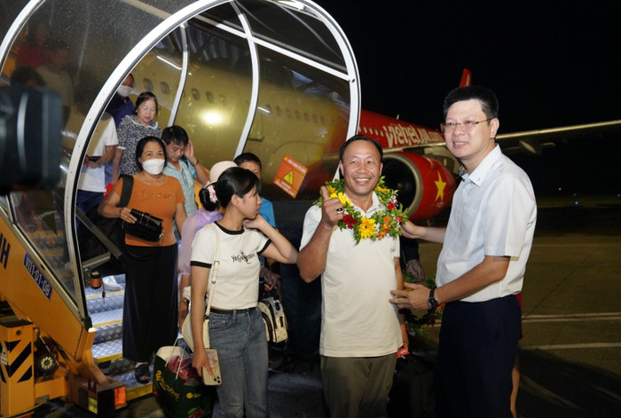 Giám Đốc Cảng Hàng Không Quốc Tế Vinh Nghiêm Mạnh Tuấn (áo trắng) và Phó Tổng giám đốc Vietjet Nguyễn Đức Thịnh (áo vest đen) tặng hoa chào đón hành khách từ Buôn Ma Thuột đến Vinh. A5-5.jpg