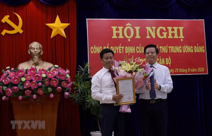 Ông Mai Văn Chính, Ủy viên Trung ương Đảng, Phó trưởng Ban Tổ chức Trung ương trao Quyết định của ban Bí thư cho ông Lê Quân. (Ảnh: Kim Há/TTXVN)