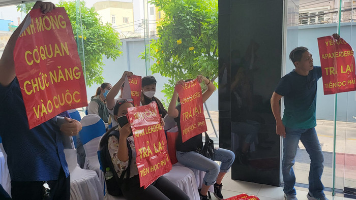 Phụ huynh giơ cao khẩu hiệu đòi lại học phí tại buổi đối thoại (ảnh: P.L) Phụ huynh giơ cao khẩu hiệu đòi lại học phí tại buổi đối thoại (ảnh: P.L)