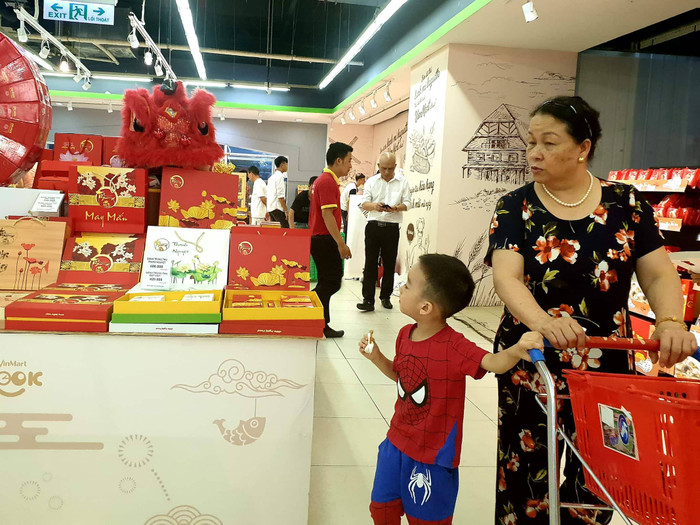 Bé trai thích thú với quầy bánh trung thu đẹp mắt tại VinMart khi được đi siêu thị cùng bà Bé trai thích thú với quầy bánh trung thu đẹp mắt tại VinMart khi được đi siêu thị cùng bà