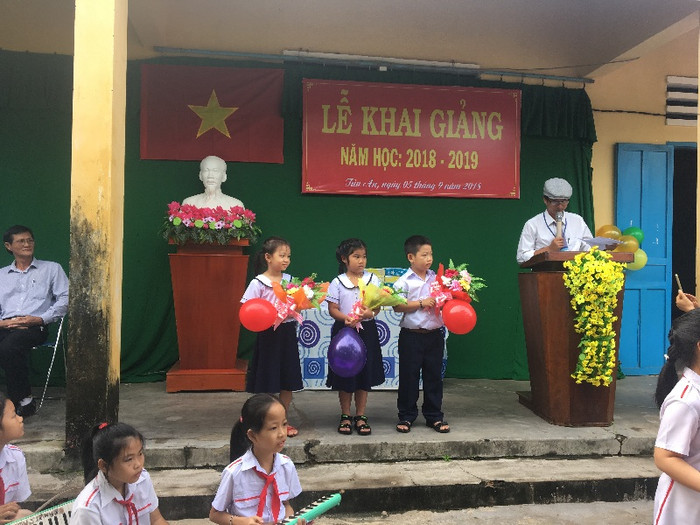 Đại diện học sinh lớp 1 nhận hoa của học sinh lớp 5