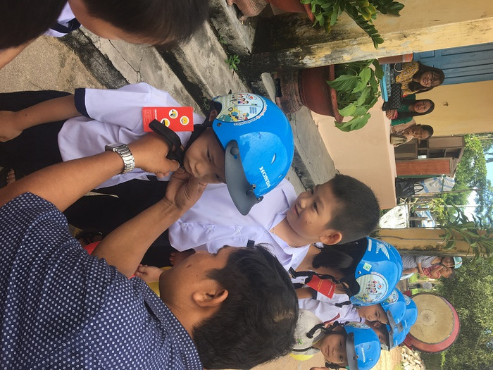 Thầy giáo đại diện công ty Honda phát mũ bảo hiểm học sinh lớp 1