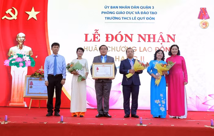 Ông Phạm Đăng Khoa – Hiệu trưởng trường Trung học cơ sở Lê Quý Đôn Quận 3, Thành phố Hồ Chí Minh cùng đại diện thầy cô giáo của trường nhận Huân chương Lao động hạng Nhì do Chủ tịch nước trao tặng cho trường. Ảnh: Lý Võ Phú Hưng