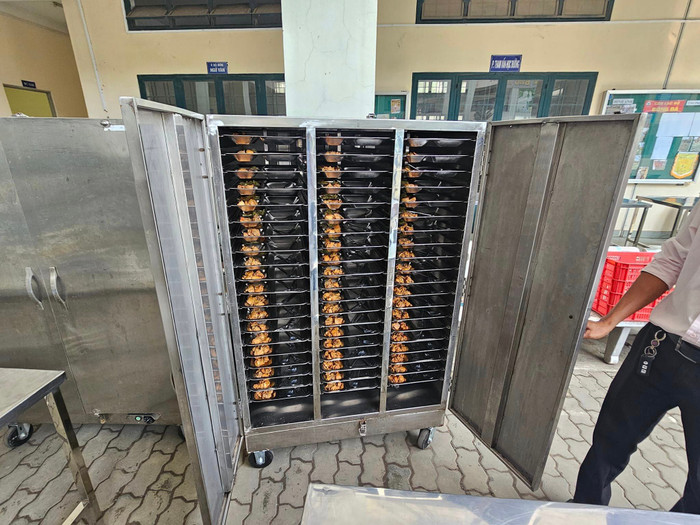 Các suất ăn đang được máy ủ nóng trước khi giao về cho học sinh ăn (ảnh: V.D) gdvn_bepBHHb.jpg