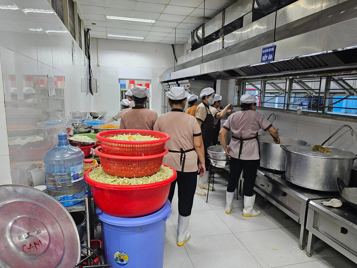 Các nhân viên đang chế biến suất ăn trưa cho học sinh Trường Trần Văn Ơn (ảnh: V.D) gdvn_TVObepb.jpg