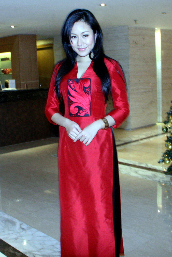 Cô diện một chiếc áo dài màu đỏ.