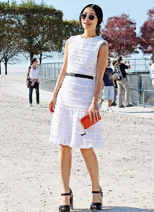 Váy điệu màu trắng được đi kèm thắt lưng và sandal màu đen sang trọng