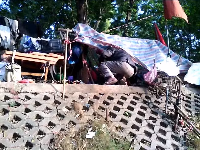 Ông Lão đang loay hoay chui vào lều để lấy chiếc điếu cày