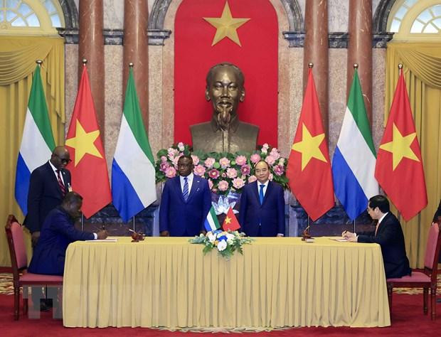 Chủ tịch nước Nguyễn Xuân Phúc và Tổng thống nước Cộng hòa Sierra Leone Julius Maada Bio chứng kiến lễ ký kết hợp tác giữa hai nước. (Ảnh: Thống Nhất/TTXVN) Chủ tịch nước Nguyễn Xuân Phúc và Tổng thống nước Cộng hòa Sierra Leone Julius Maada Bio chứng kiến lễ ký kết hợp tác giữa hai nước. (Ảnh: Thống Nhất/TTXVN)