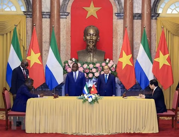 Chủ tịch nước Nguyễn Xuân Phúc và Tổng thống nước Cộng hòa Sierra Leone Julius Maada Bio chứng kiến lễ ký kết hợp tác giữa hai nước. (Ảnh: Thống Nhất/TTXVN)