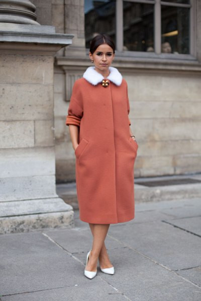 Chiếc áo khoác màu đỏ gạch nổi bật với sự kết hợp của chiếc cổ lông trắng, càng thêm phần tinh tế hơn khi đi kèm với đôi giày màu trắng. Chiếc áo khoác màu đỏ gạch nổi bật với sự kết hợp của chiếc cổ lông trắng, càng thêm phần tinh tế hơn khi đi kèm với đôi giày màu trắng.