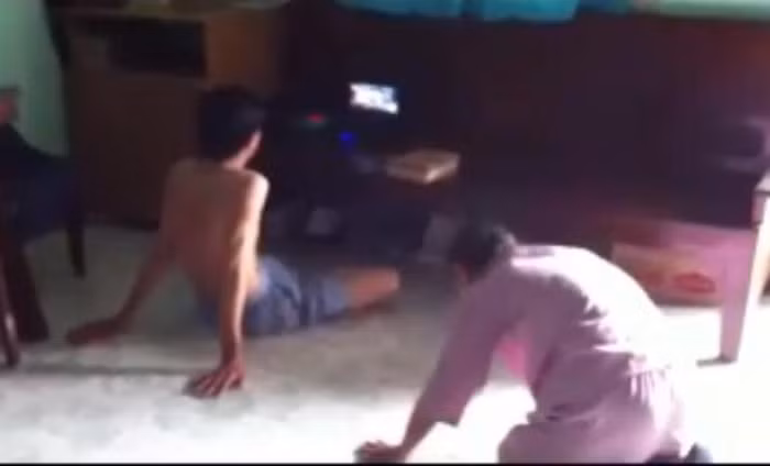 Người mẹ già vừa quỳ vừa lạy, con trai thì thản nhiên xem tivi như không có chuyện gì