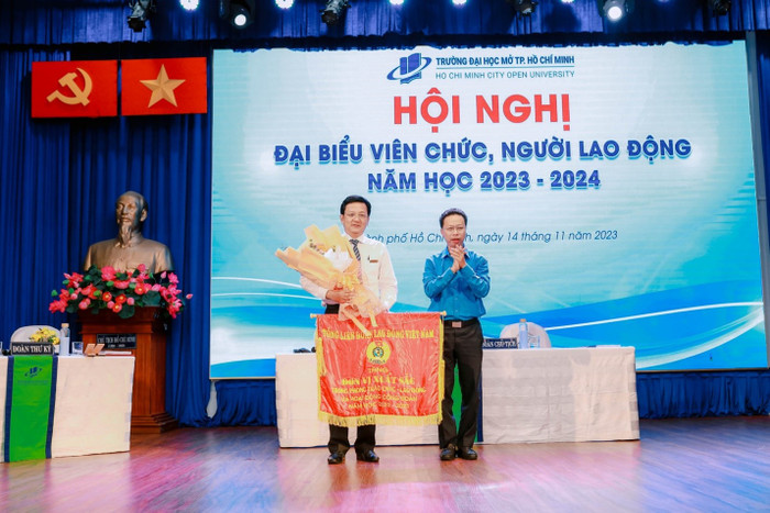 Thạc sĩ Nguyễn Thành Đô - Ủy viên Ban Thường vụ - Trưởng ban Chính sách Pháp luật Liên đoàn Lao động Thành phố Hồ Chí Minh trao tặng Cờ Tổng Liên đoàn Lao động Việt Nam cho Tiến sĩ, Giảng viên cao cấp Lê Xuân Trường - Chủ tịch Công đoàn Trường Đại học Mở Thành phố Hồ Chí Minh. dhmo3.jpg