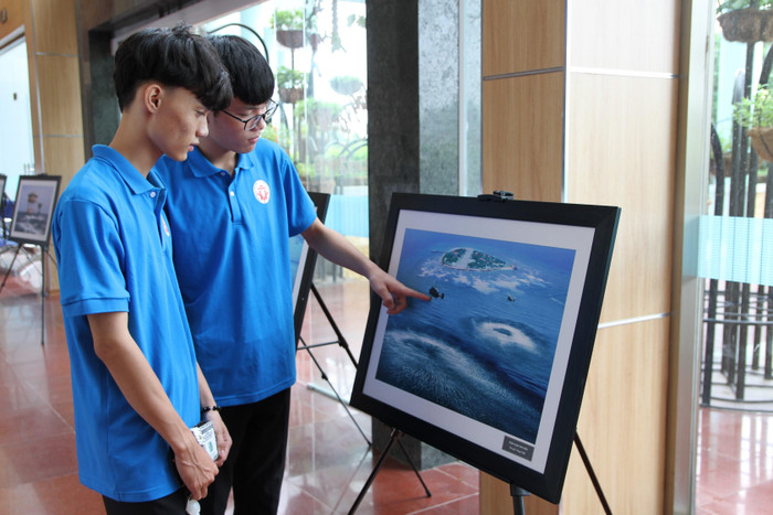 Hai bạn trẻ xem bức tranh Huấn luyện trên biển của tác giả Trọng Thiết.