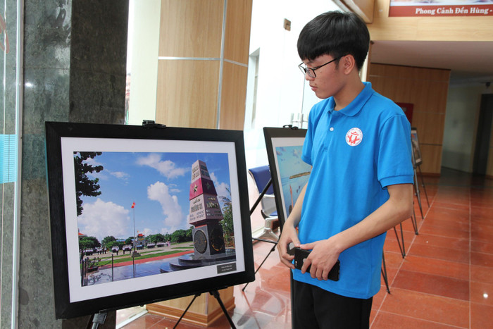 Nam sinh viên Đại học Hùng Vương xúc động trước hình ảnh Chào cờ đầu tuần của tác giả Trọng Thiết trên đảo Trường Sa. Ảnh: Vũ Phương.