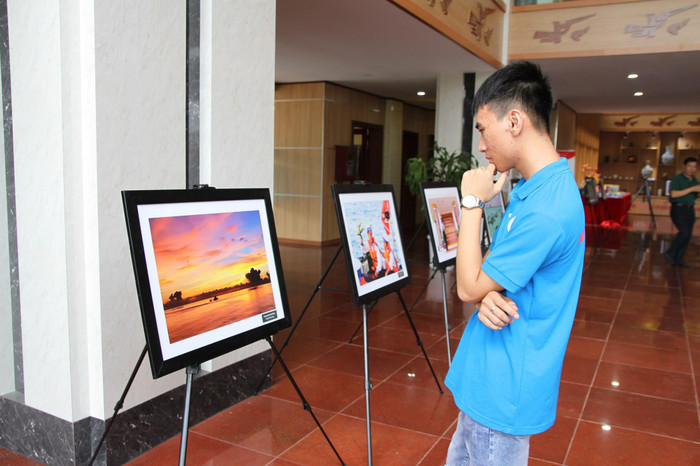 Sinh viên Phạm Tuấn Anh ngắm nhìn rất kỹ từng bức tranh tại triển lãm. Những bức ảnh thật sự làm Tuấn Anh xúc động mạnh. Ảnh: Vũ Phương.