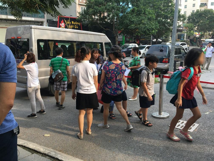 Học sinh xuống xe được yêu cầu xếp hàng kiểm đếm trước khi vào trường. Học sinh xuống xe được yêu cầu xếp hàng kiểm đếm trước khi vào trường.