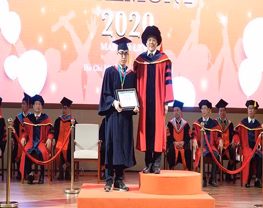 Thủ khoa Phan Ngọc Hưng nhận bằng tốt nghiệp sau đại học từ hiệu trưởng nhà trường (ảnh: CTV)