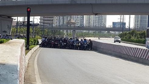 Người đi đường dừng đèn đỏ ở nơi bóng mát tại chân cầu vượt Cái Lái, Q.2 (ảnh: T.P)