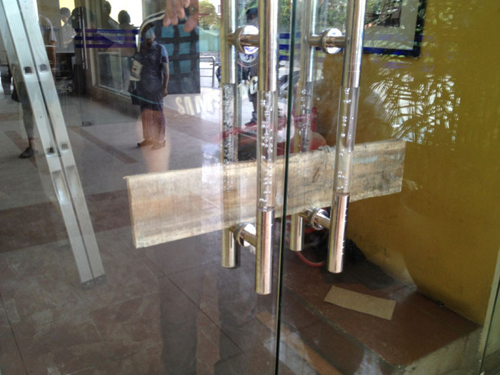 Dùng cả thanh gỗ để chèn ngang tay cầm cửa ra vào Dùng cả thanh gỗ để chèn ngang tay cầm cửa ra vào