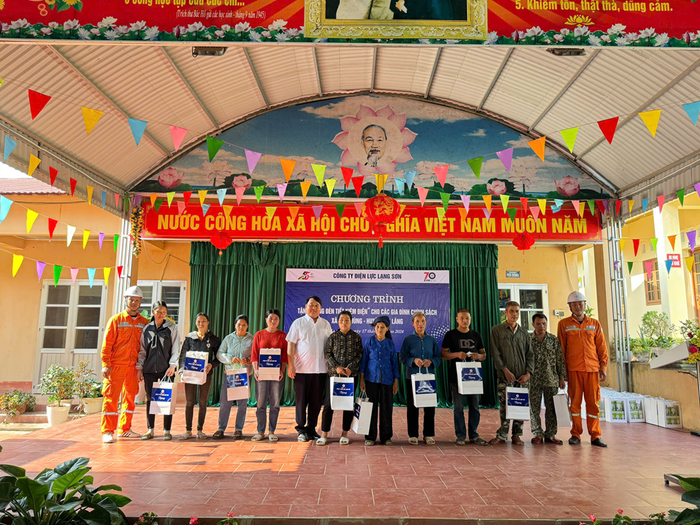 Ông Phùng Minh Hiếu – Giám đốc Điện lực Văn Lãng trao tặng bóng đèn tiết kiệm điện cho đại diện các hộ gia đình.