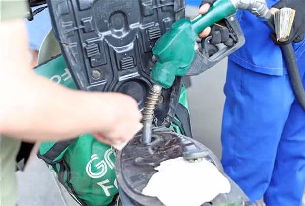Mua bán xăng, dầu tại điểm kinh doanh xăng dầu Petrolimex. (Ảnh: Trần Việt/TTXVN)