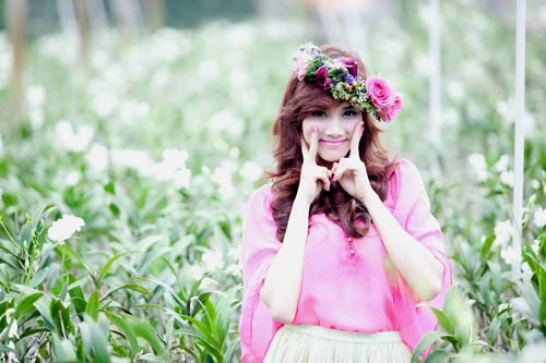 Giữa cánh đồng hoa trắng, cô nổi bật lên như một bông hồng xinh tươi khi diện áo, tô son môi, sơn móng tay màu hồng.