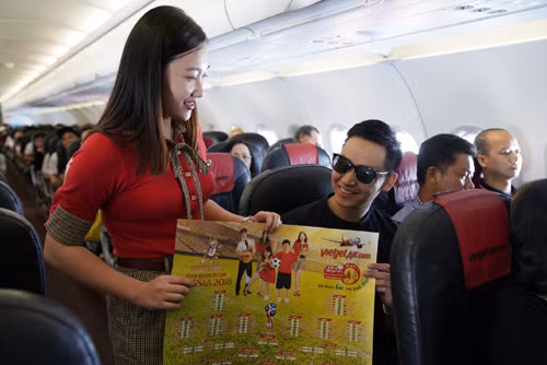 Nhiều hành khách bất ngờ và vui mừn nhận bộ lịch thi đấu rực rỡ sắc màu, trẻ trung, năng động có đầy đủ thông tin về giải đấu được trông đợi nhất hành tinh World Cup 2018 của hãng hàng không Vietjet. Ảnh: Vietjet